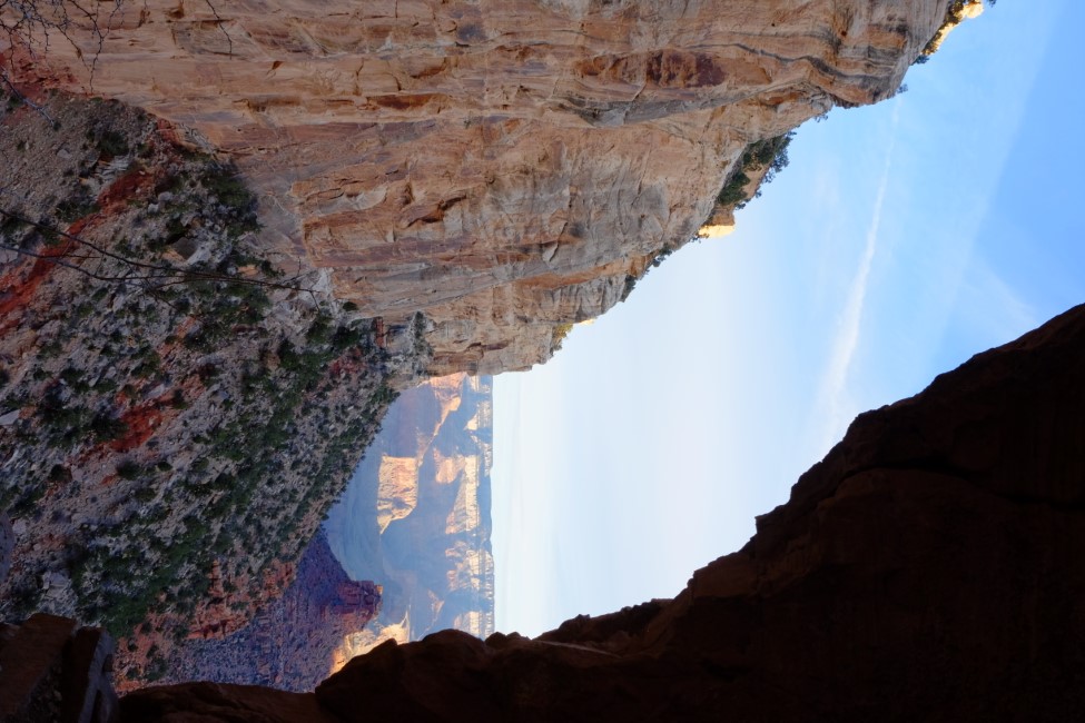 part of the grand canyon, viewed through a gap in a rock wall.