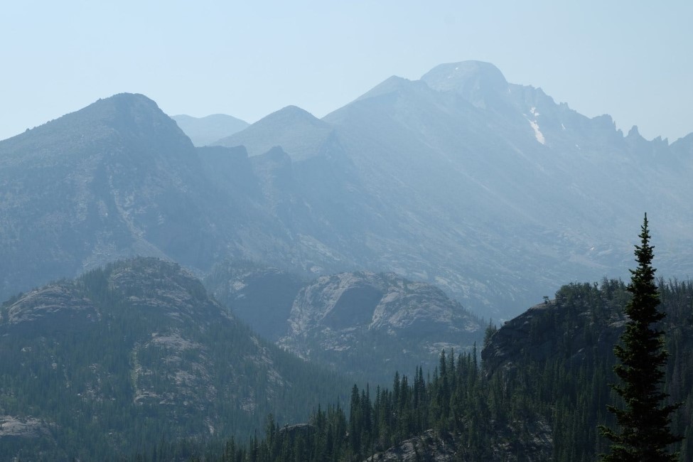 a section of the rocky mountains. heavy haze in the air makes the mountains fade into the distance.